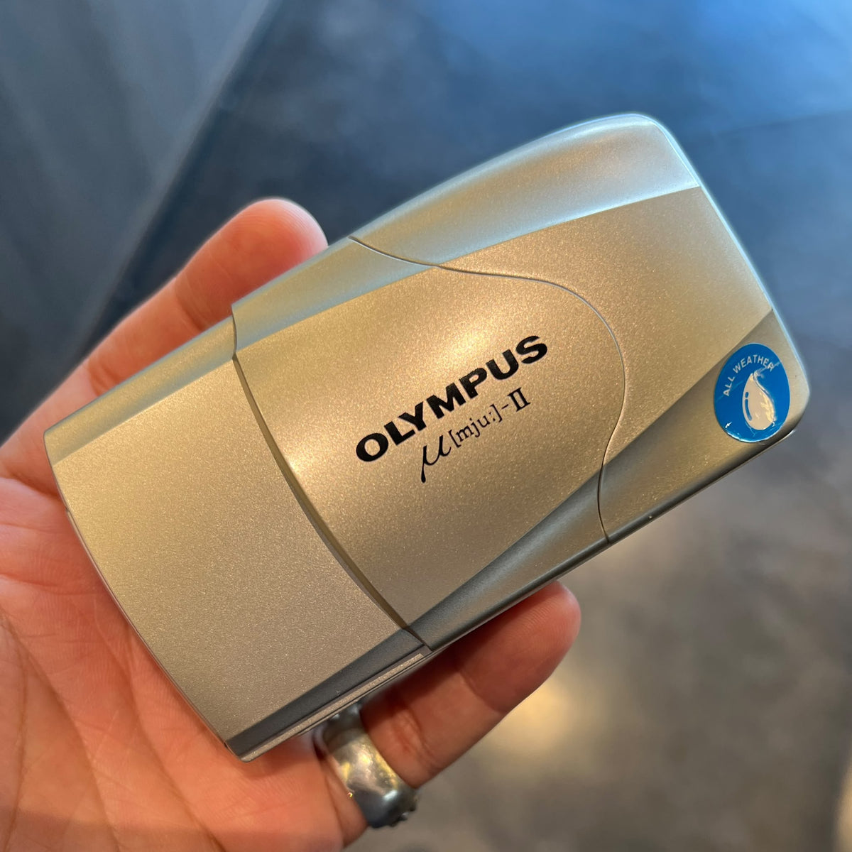 The Olympus Mju II 35mm film camera in silver, front view, a compact vintage camera for sale in Australia
