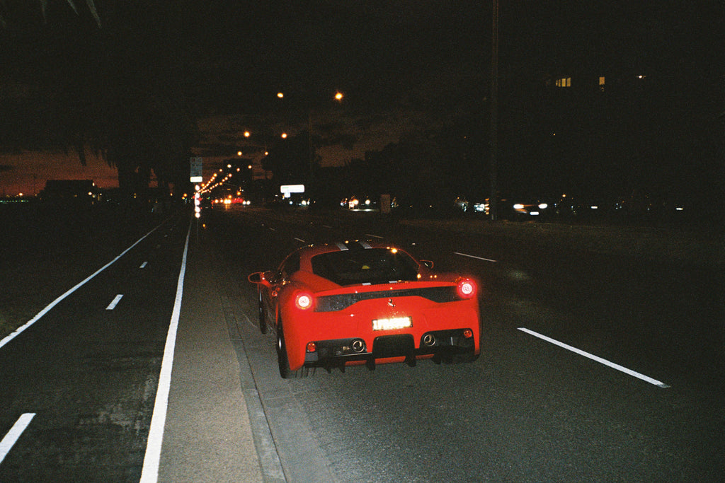 A Ferrari parked up on a empty road
