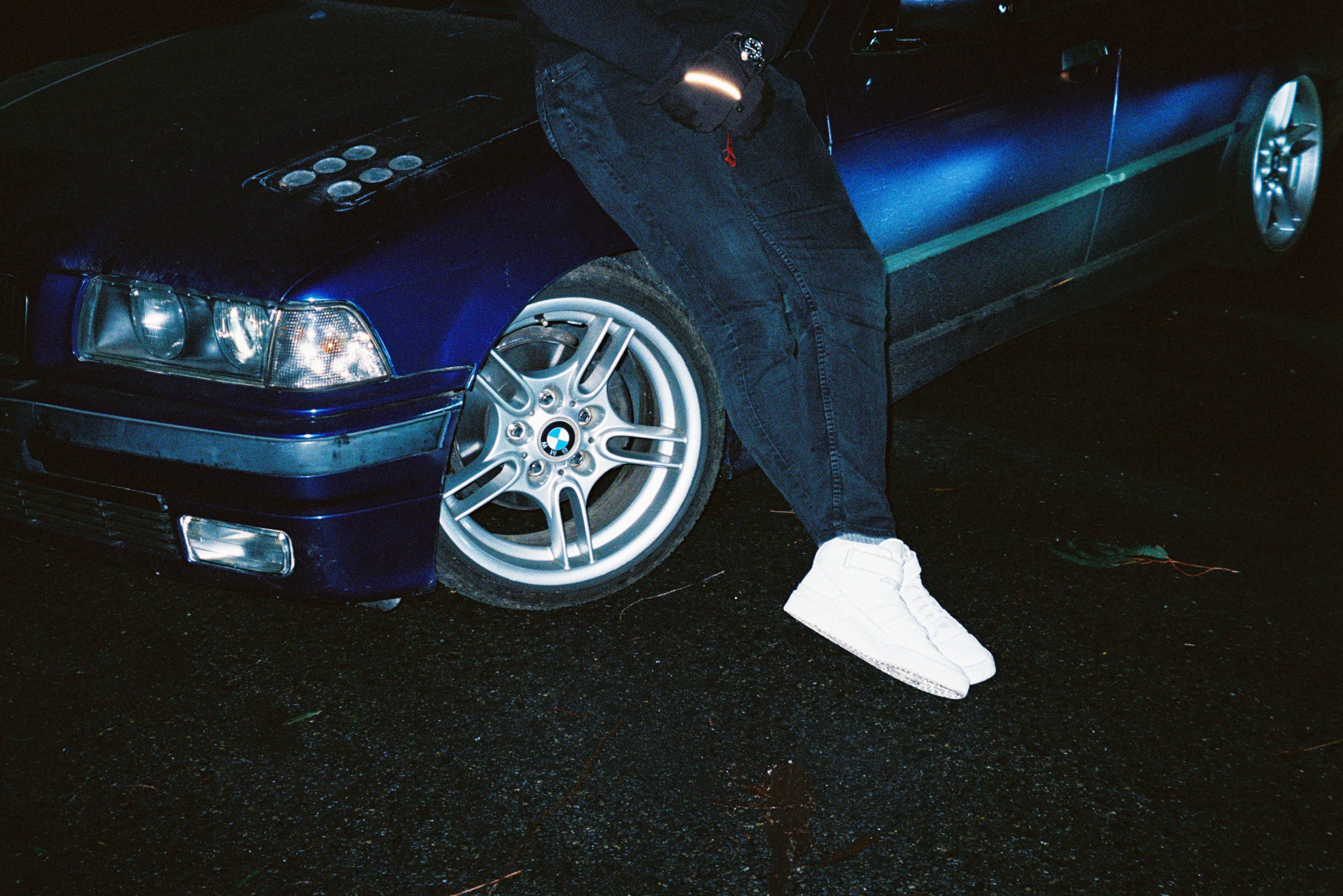 A man posing next to his car