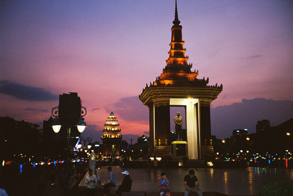 A statue and monument in Vietnam with the sun setting in the background 