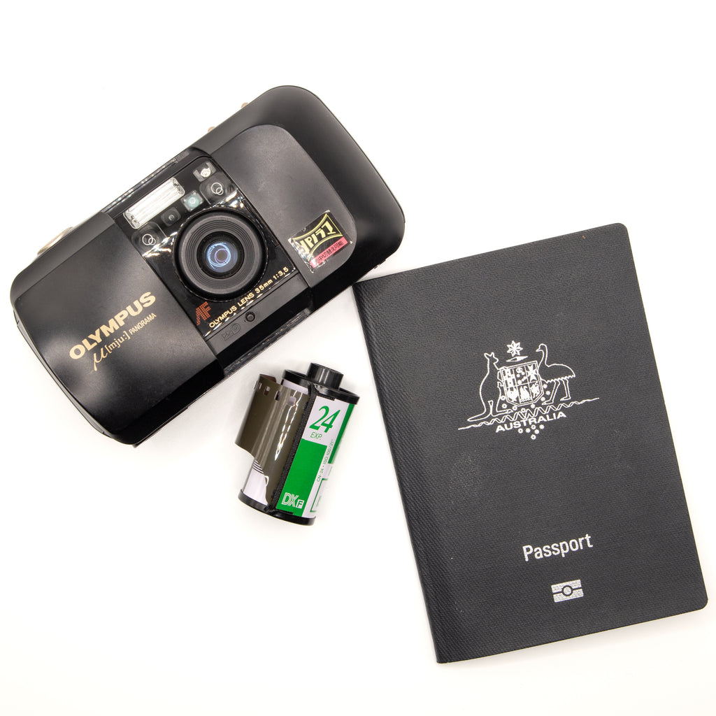 A film camera, a roll of 35mm film and a passport