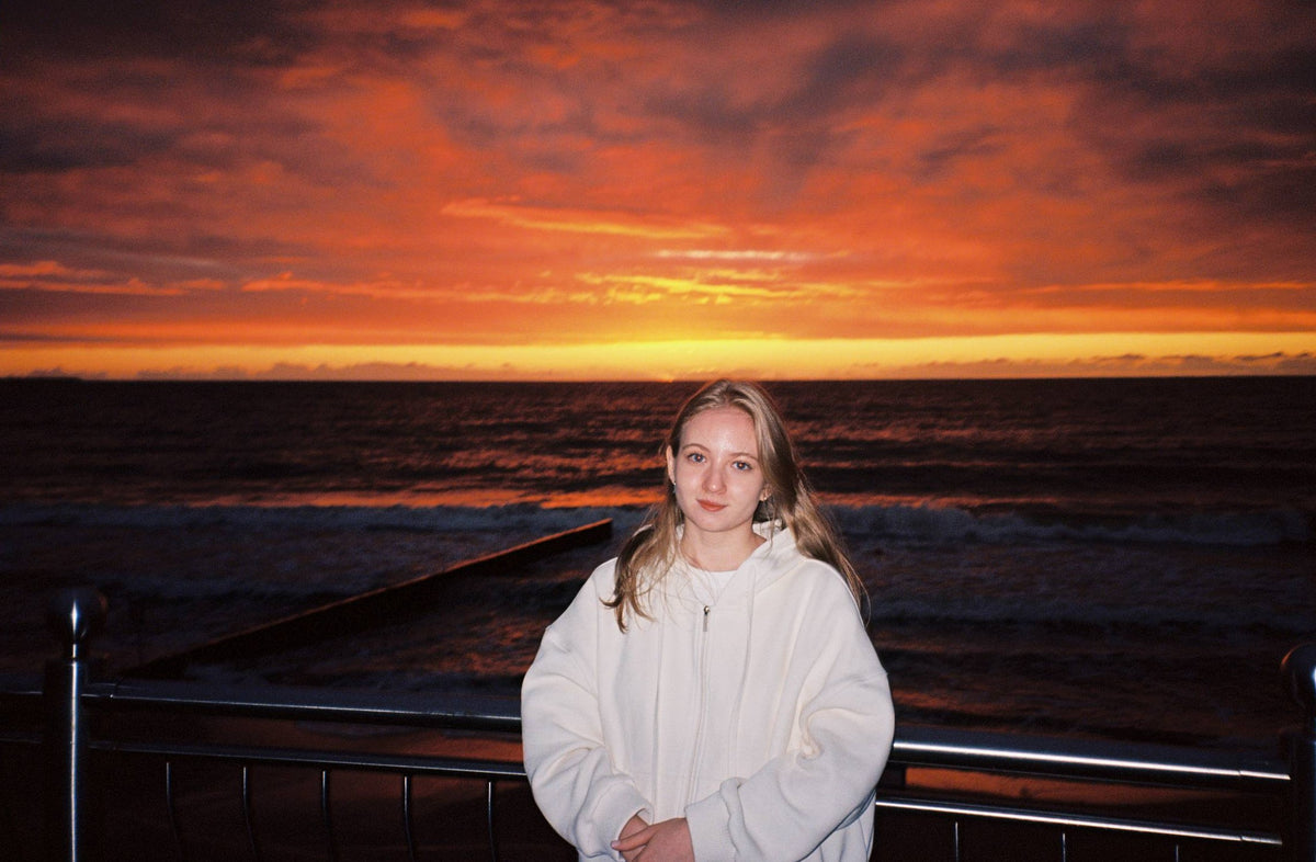 Sample photo taken with the Minolta Riva Zoom 70 35mm film camera. Girl standing in front of sunset.