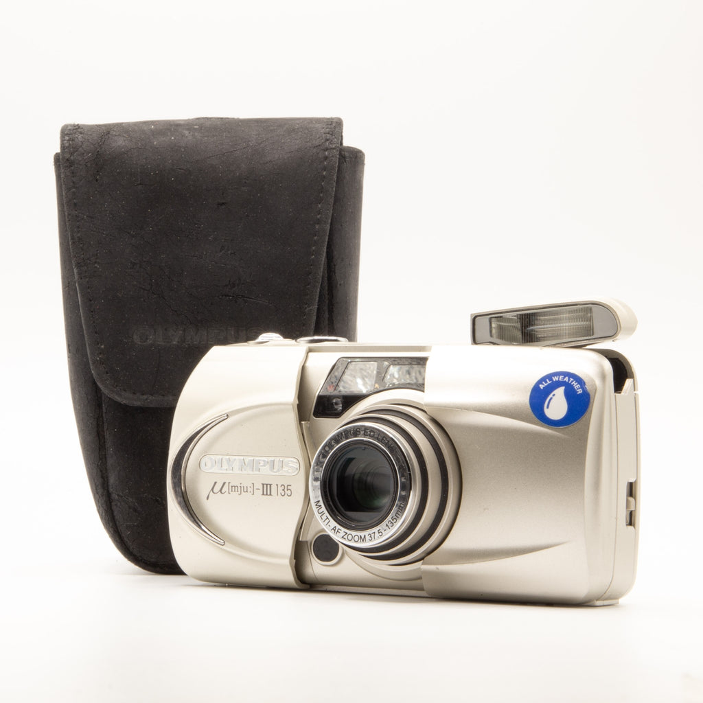 A photo of a vintage Olympus 35mm point-and-shoot film camera and a camera case