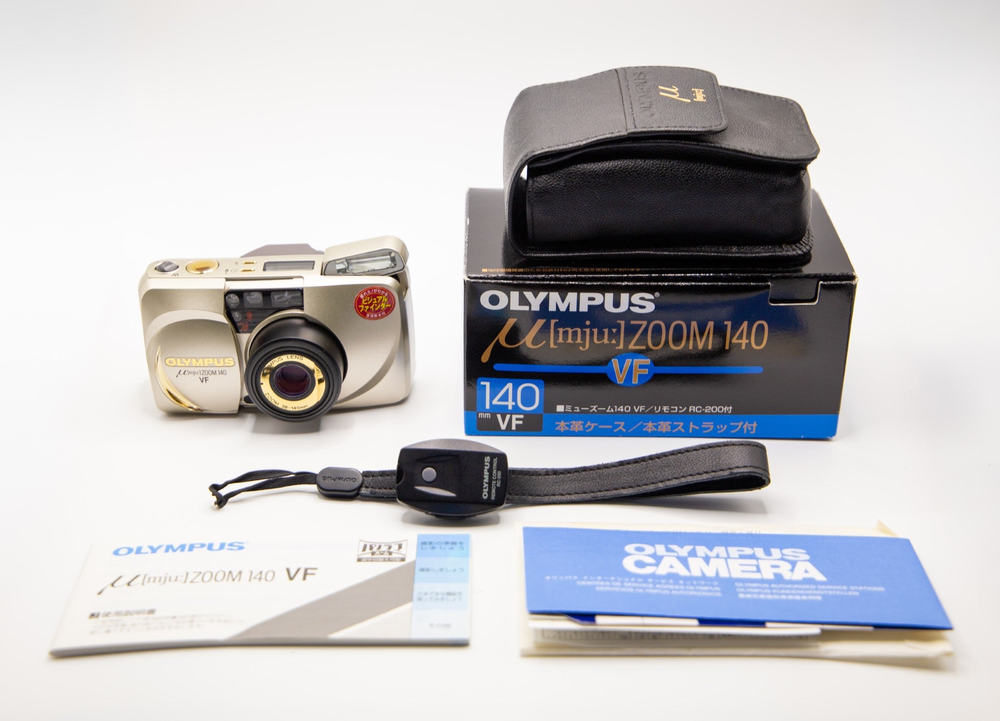 Olympus camera with packaging and accessories on a white background