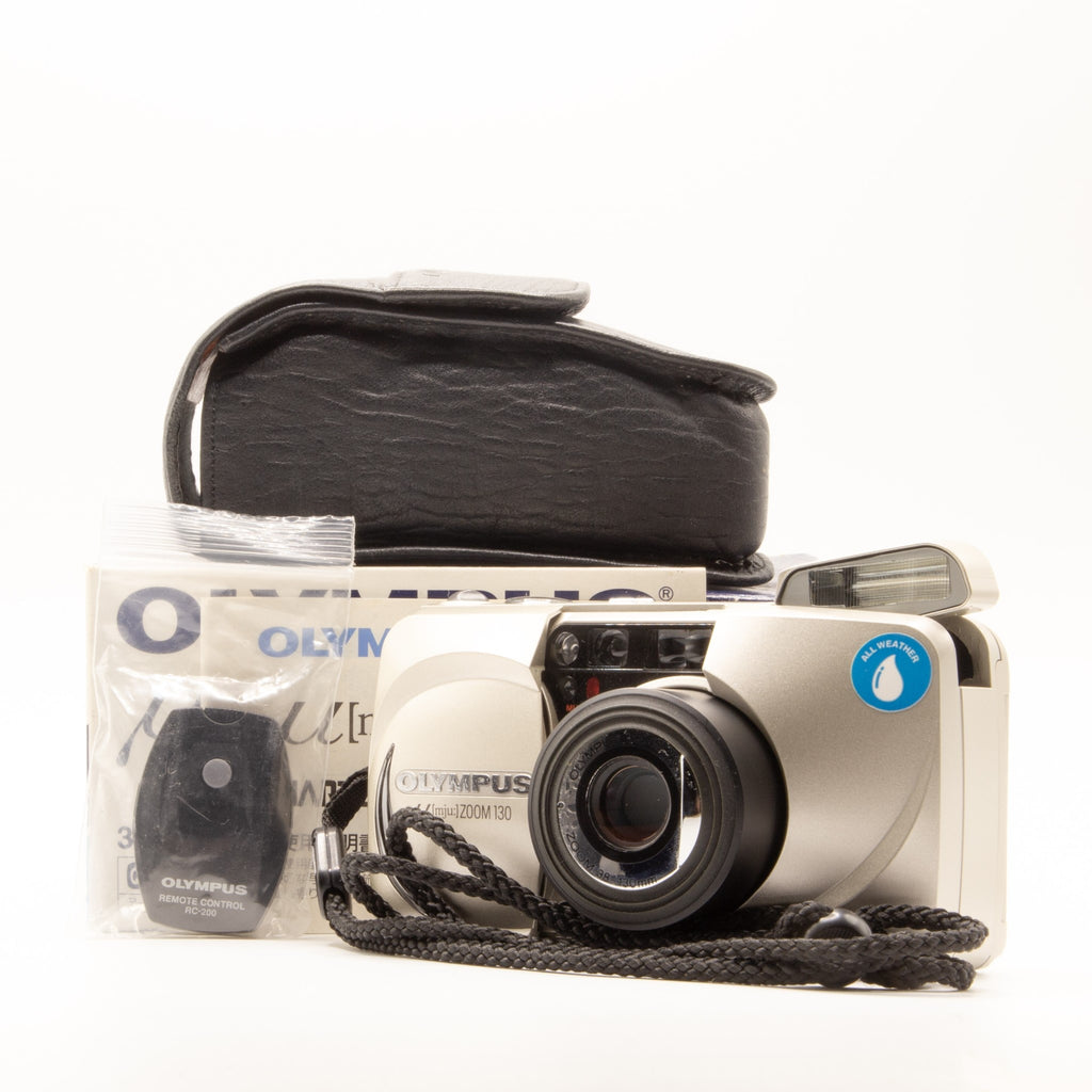 A photo of a vintage Olympus 35mm point-and-shoot film camera with box and accessories